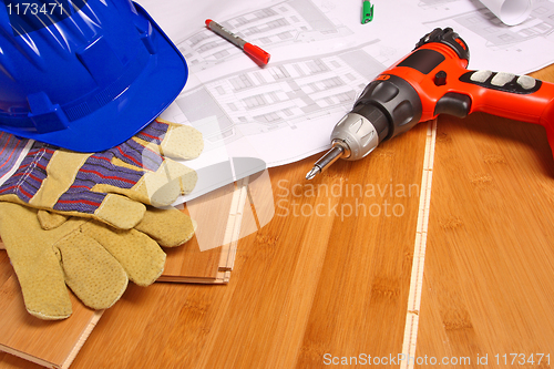 Image of helmet and blueprint on wood floor