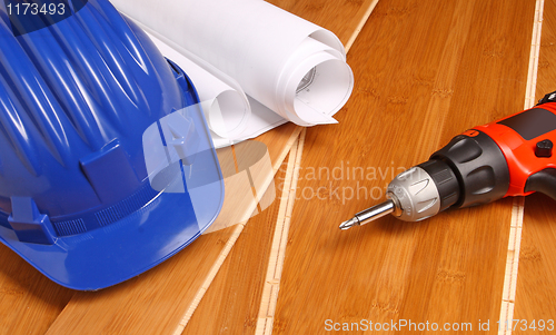 Image of helmet, drill and blueprint 