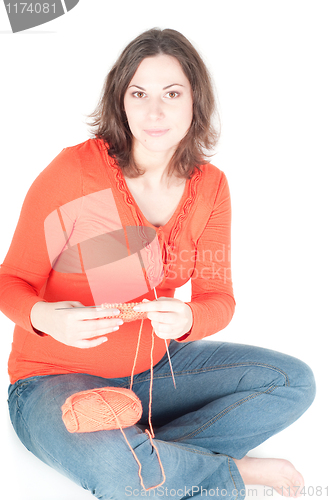 Image of Portrait of pretty pregnant woman knitting