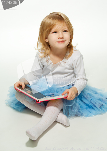 Image of Small girl reading a book and smiling