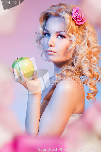 Image of Curly blond woman with green apple