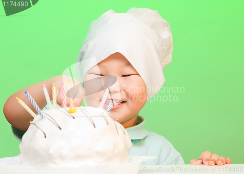 Image of Boy putting candles in birthday cake