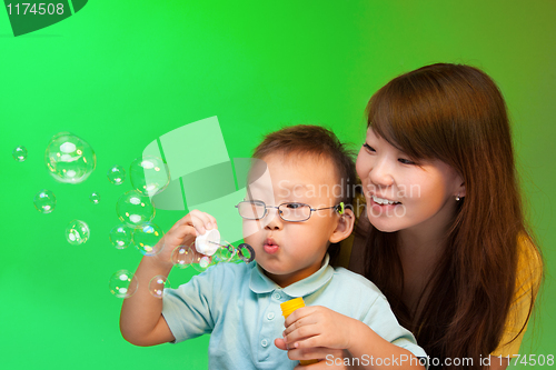 Image of Mother and son make soap bubbles