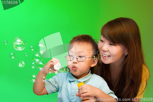 Image of Mother and son make soap bubbles