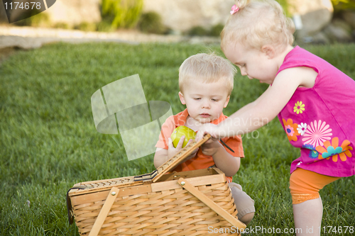 Image of Brother and Sister Toddlers Playing with Apple and Picnic Basket