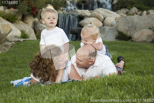 Image of Couple Gaze at each other as Cute Twins Look On.