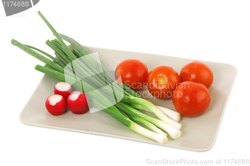 Image of white plate with tomato, radish and green onion
