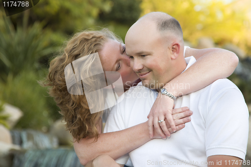 Image of Attractive Couple Kiss on the Cheek in the Park.