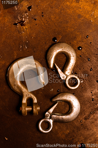 Image of Rusty crane hooks on metal plate