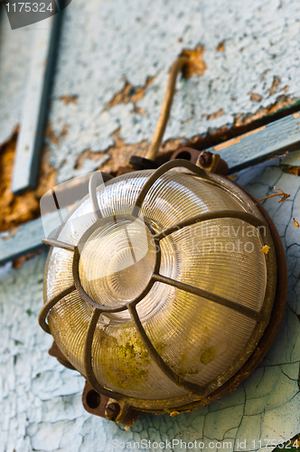 Image of Old and dirty lamp on blue abandoned wall