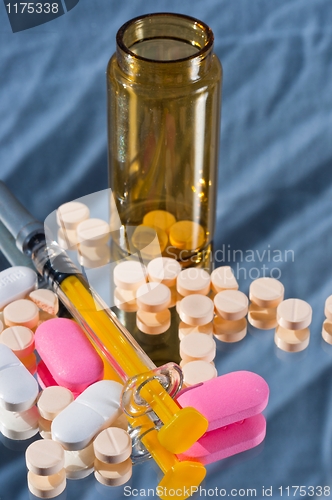 Image of Medicine bottle and sirynge and pills and reflection