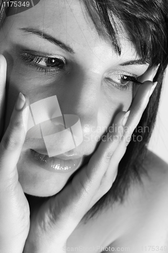 Image of young woman holding her face with hands in black and white