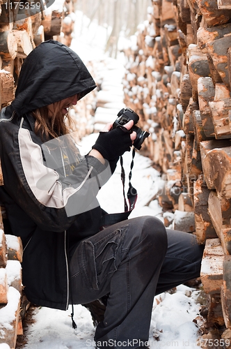 Image of Photographer between logs of wood