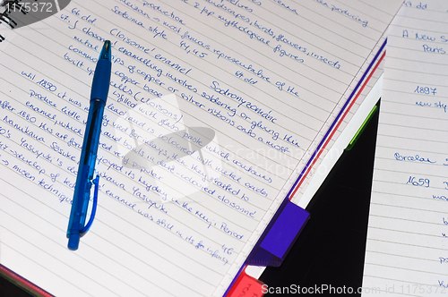 Image of Notebook with a blue pen and text on it