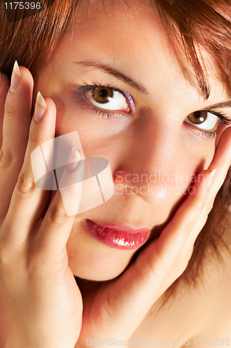 Image of Young woman holding her face