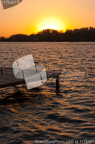 Image of A pier on the shore with sunset