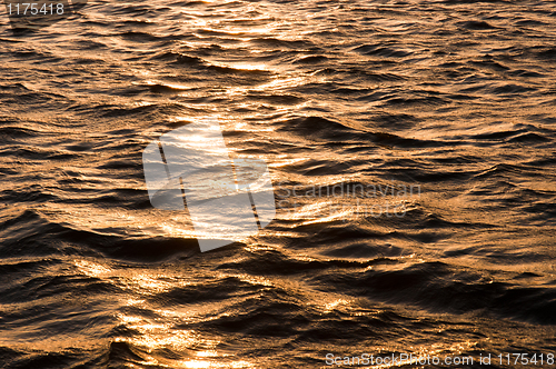 Image of Waves of water reflecting the sunset