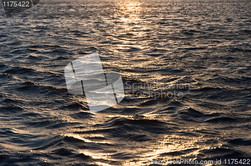 Image of Waves of water reflecting the sunset