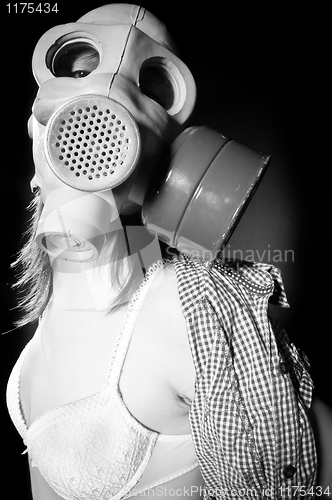 Image of Girl in gasmask and lingerie against black background in black a