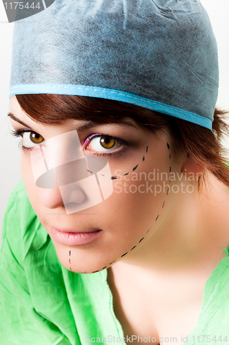 Image of Drawn lines on a young woman face as marks for facial plastic su