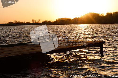 Image of A pier on the shore with sunset