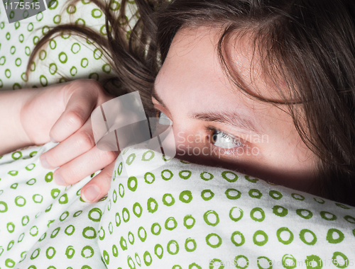 Image of Girl scared of something under blanket