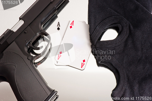 Image of A pair of aces with a mask and a pistol of a thief