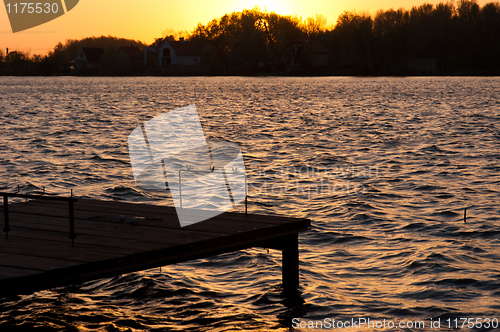 Image of A pier on the shore with sunset