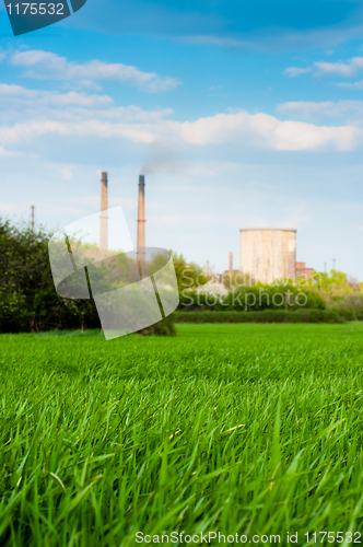 Image of Fresh green grass with nuclear power plant and blue sky