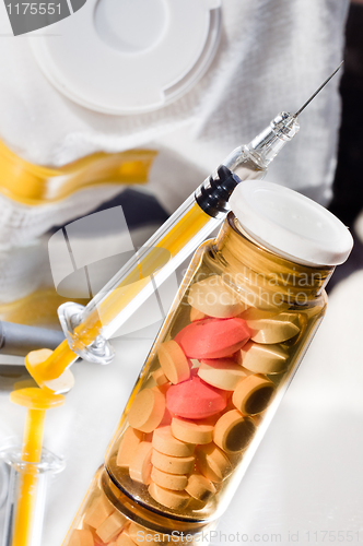 Image of Medicine glass bottle with pills and syringe with protective mas