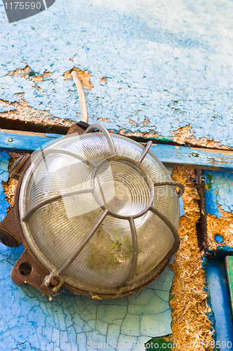 Image of Old and dirty lamp on blue abandoned wall