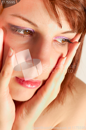Image of Closeup of a young woman holding her face with hands