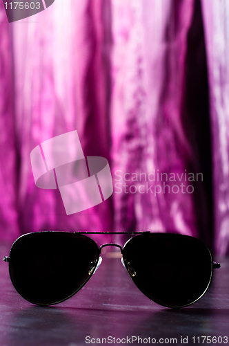 Image of Sunglasses against purple blurry background