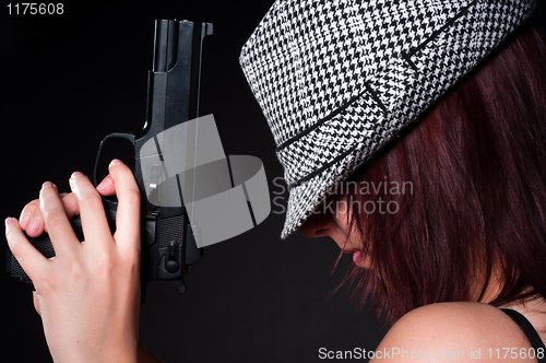 Image of Girl in hat with a big pistol
