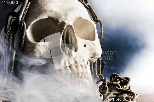 Image of human skull with chain and smoke