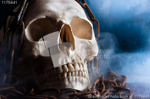 Image of human skull with chain and smoke