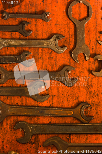 Image of Many rusty spanners on wooden board