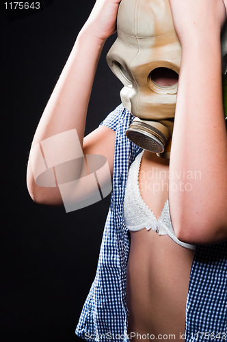 Image of Girl wearing gasmask and white lingerie holding her head