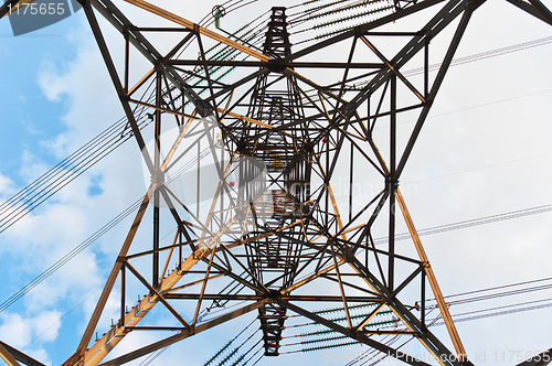 Image of angle view of a power line with clouds in the background