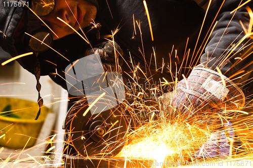 Image of Welder cutting iron with sparks