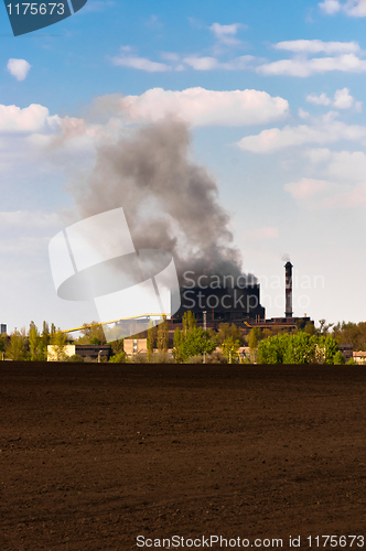 Image of Dark smoke rising from the power plant against blue background