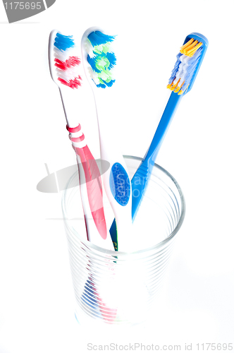 Image of colorful toothbrushes in a glass over white