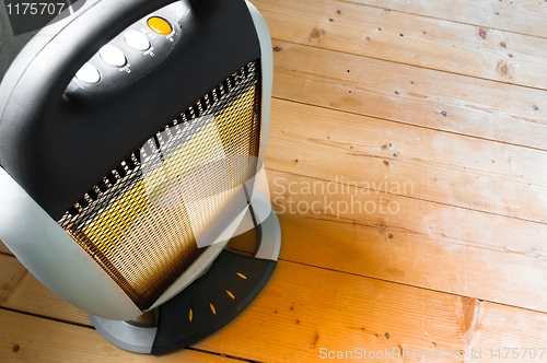 Image of Halogen or infra heater in action against wooden floor