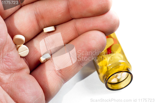 Image of Hand of a man holding pills with medicine on background
