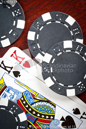 Image of A pair of kings and some tokens on wood background