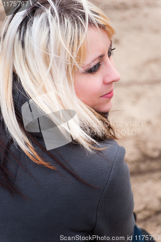 Image of Beautiful young blonde girl looks back