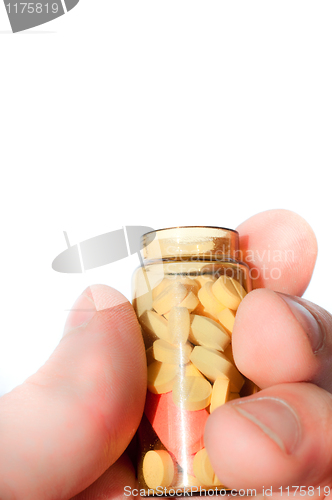 Image of Hand holding medicine bottle full of pills