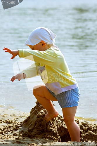 Image of Baby girl playing on the sea shore