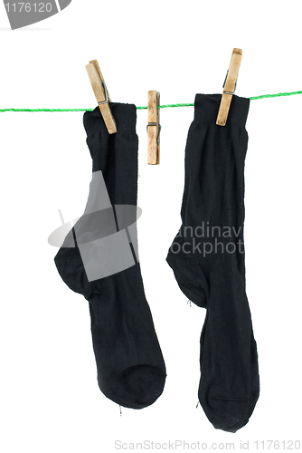 Image of Two black socks hanging on rope