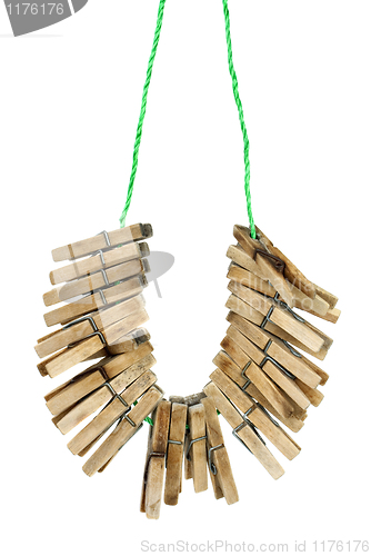 Image of Few wooden clotespins hanging on the rope
